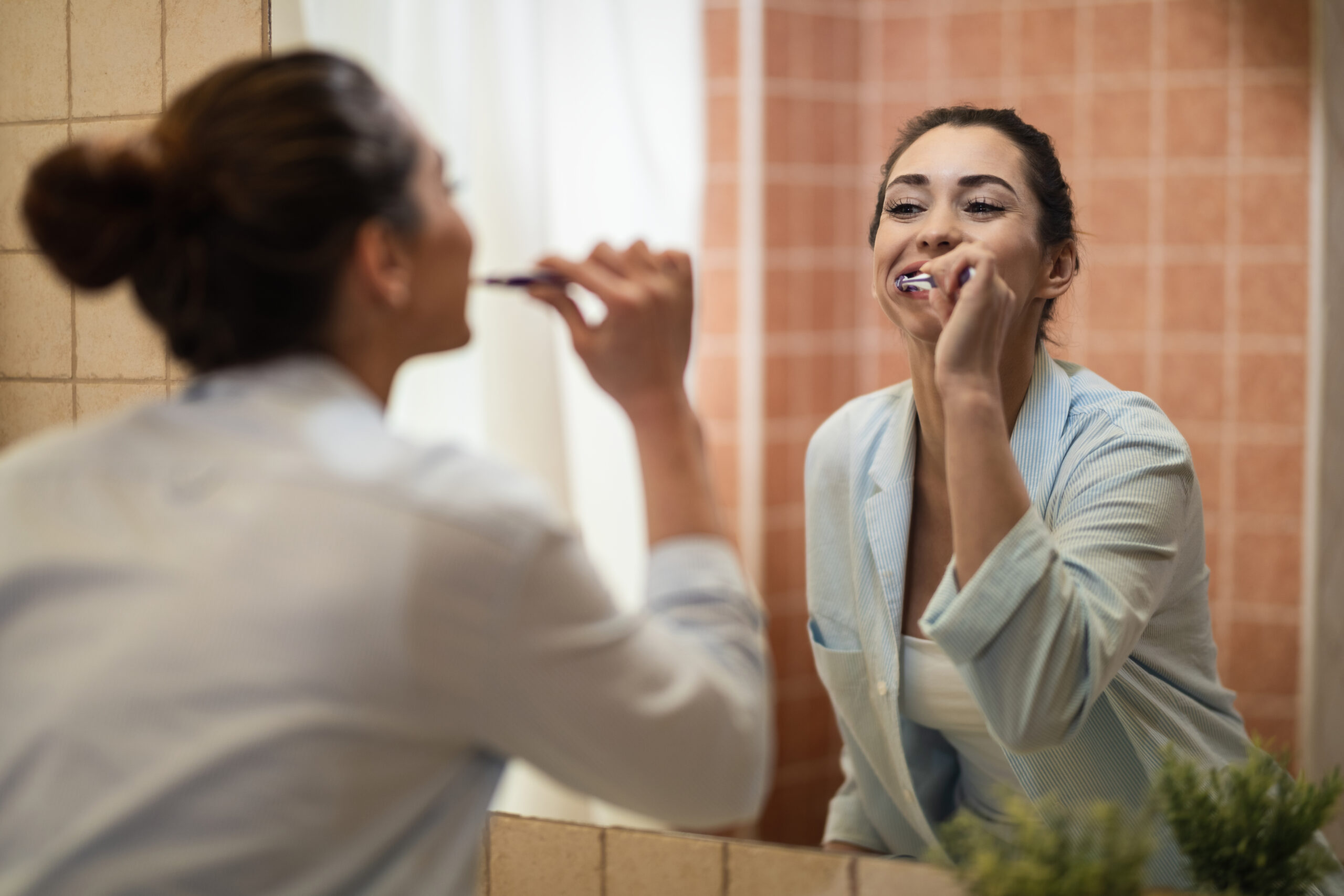 young women smiling looking in mirror